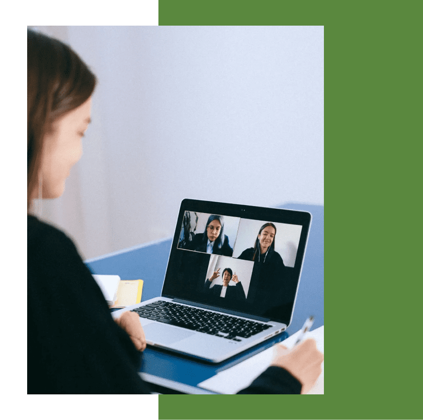 A woman is on her laptop and has two people in the screen.